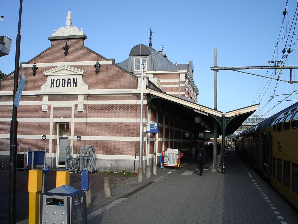 Perron van station Hoorn met de stationsnaam op de gevel en een rijtuig van de museumstoomtram